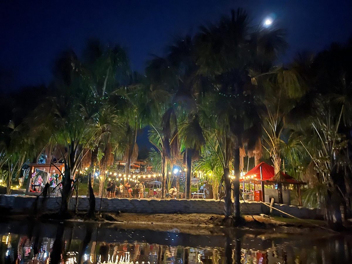 El oasis de noche visto desde la laguna, con la luna y las luces cálidas