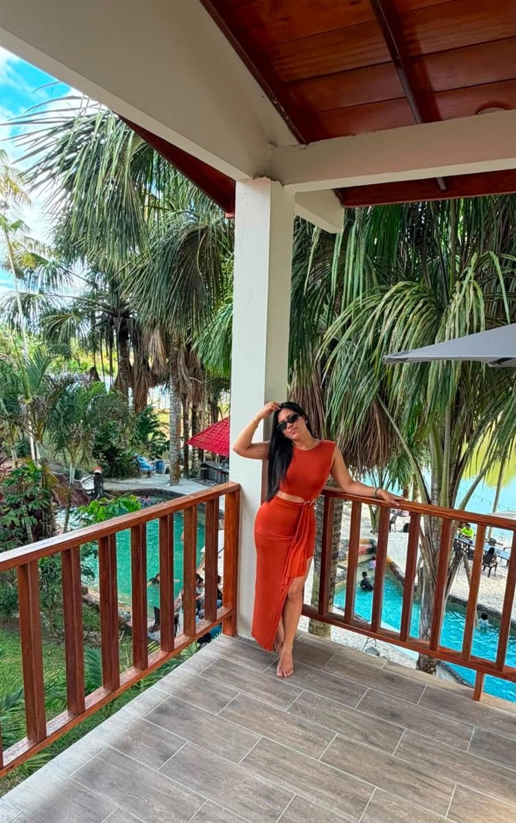 Balcón del bungalow con vista a la piscina y a las palmeras